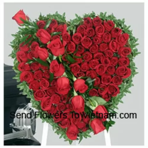 Un hermoso arreglo en forma de corazón de 100 rosas rojas