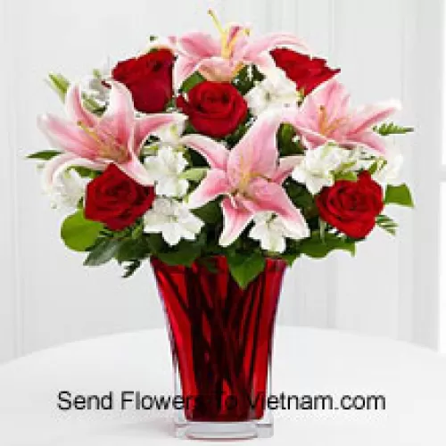 6 rosas rojas y 5 lirios rosados con relleno estacional en un hermoso jarrón de cristal
